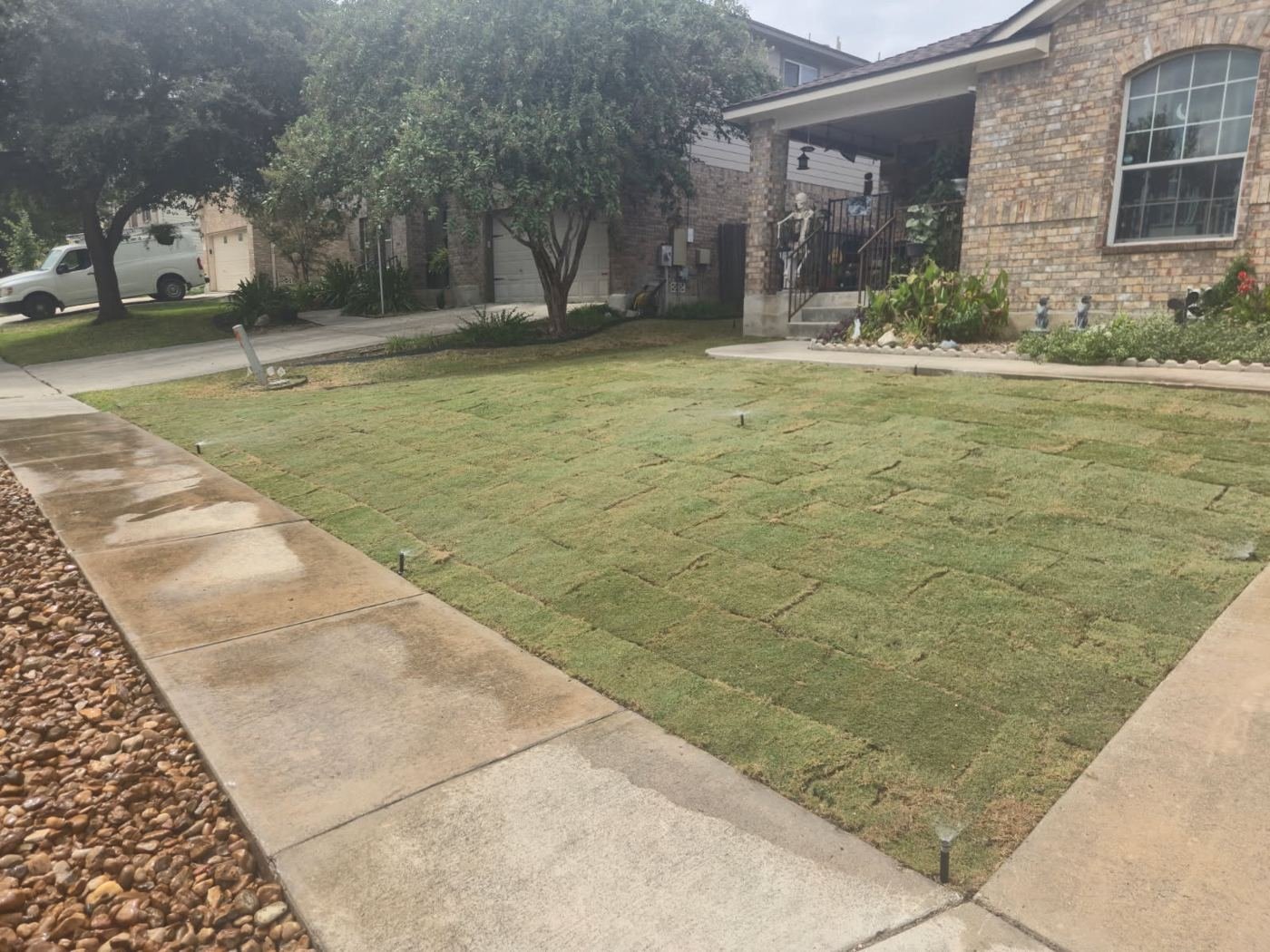 Finished Bermuda sod installation in front of a brick home